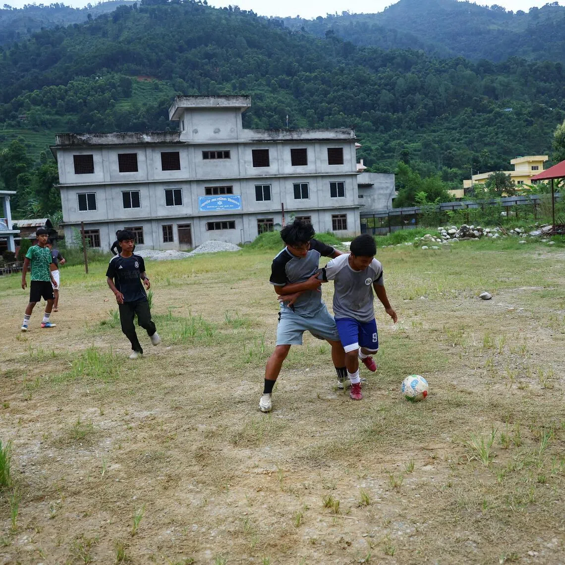 Youngsters play football at a school working as a temporary shelter in Bagmati Province, Nepal.