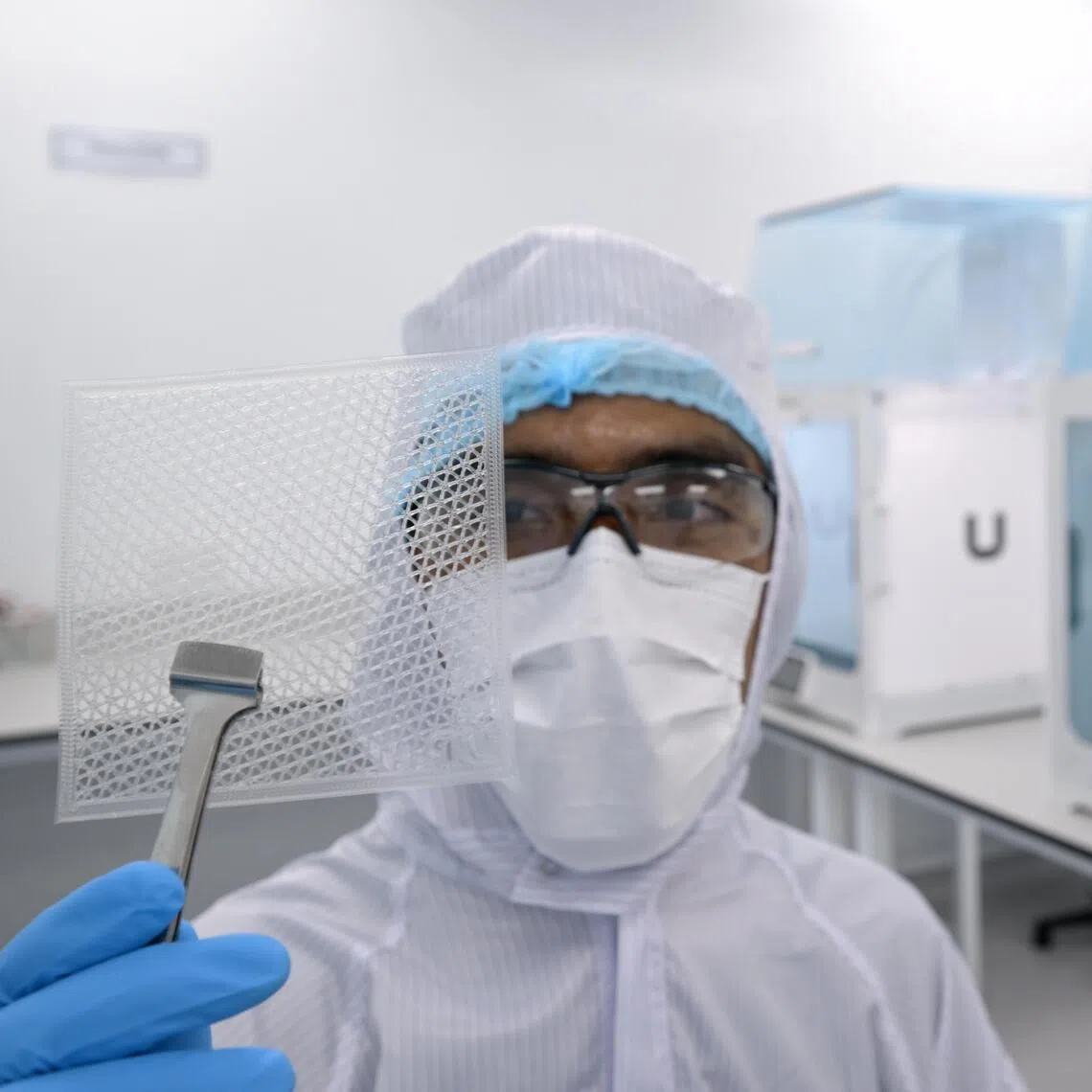 Research engineer Asyraf Abbas holds up a piece of Bioactiv Matrix, a fully synthetic skin substitute for second degree burns and deep abrasion wounds.