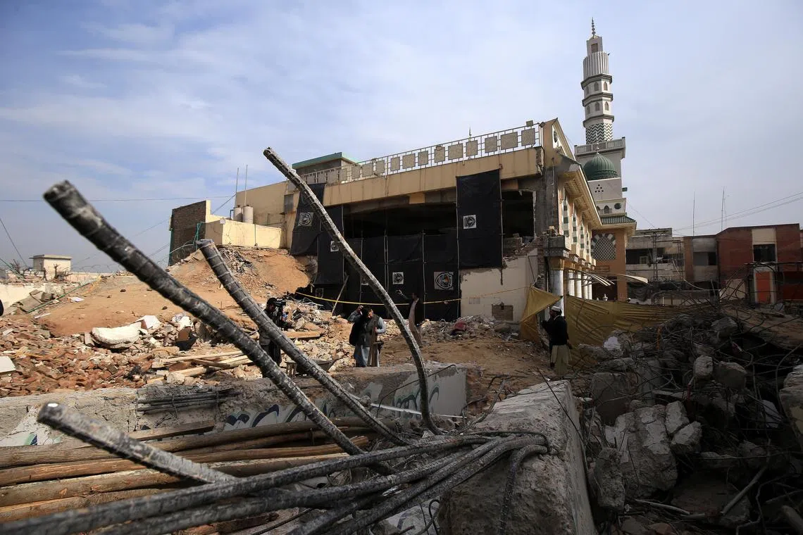 Labourers remove debris at a mosque that was destroyed in a suicide bomb blast, in Peshawar, Pakistan, on Feb 2, 2023.