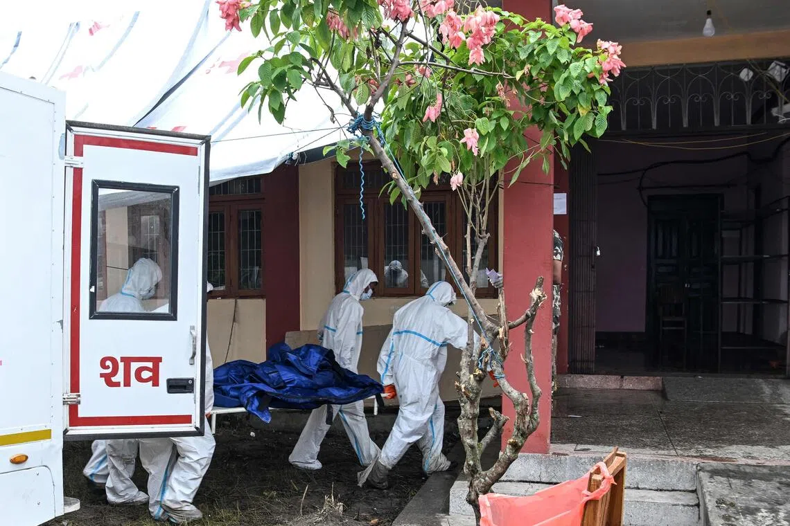 Health workers carrying a dead body at a mortuary in Nepal’s Chitwan district on Aug 30.