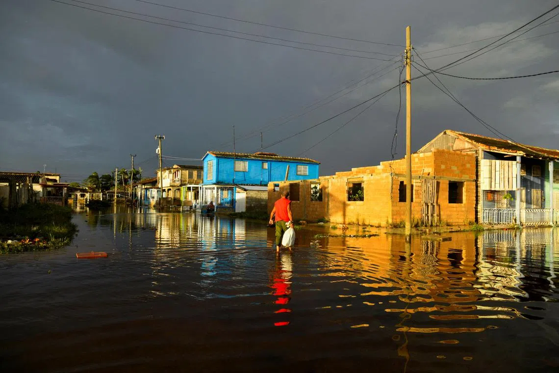 FILE PHOTO: A man walks in a flooded street a day after Hurricane Rafael made landfall in Batabano, Cuba, November 7, 2024. REUTERS/ REUTERS/Norlys Perez/File Photo