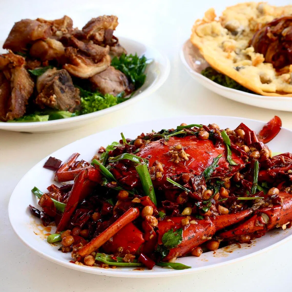 From top left, clockwise: Signature Pork Knuckle, Giant Oyster Omelette and Mala Crab at Xiao Hei Tze Char’s new outlet in New Upper Changi Road. 