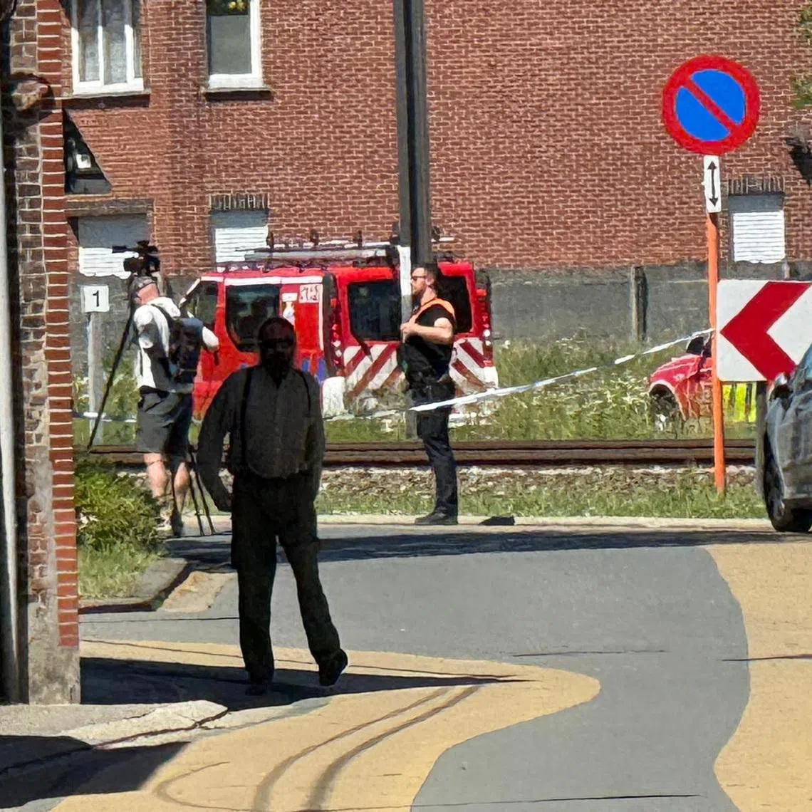 Emergency vehicles operate near the scene where a school bus was struck by a train at a level crossing leading to multiple casualities, near the town of Buggenhout, Belgium, May 26, 2026. REUTERS/Bart Biesemans