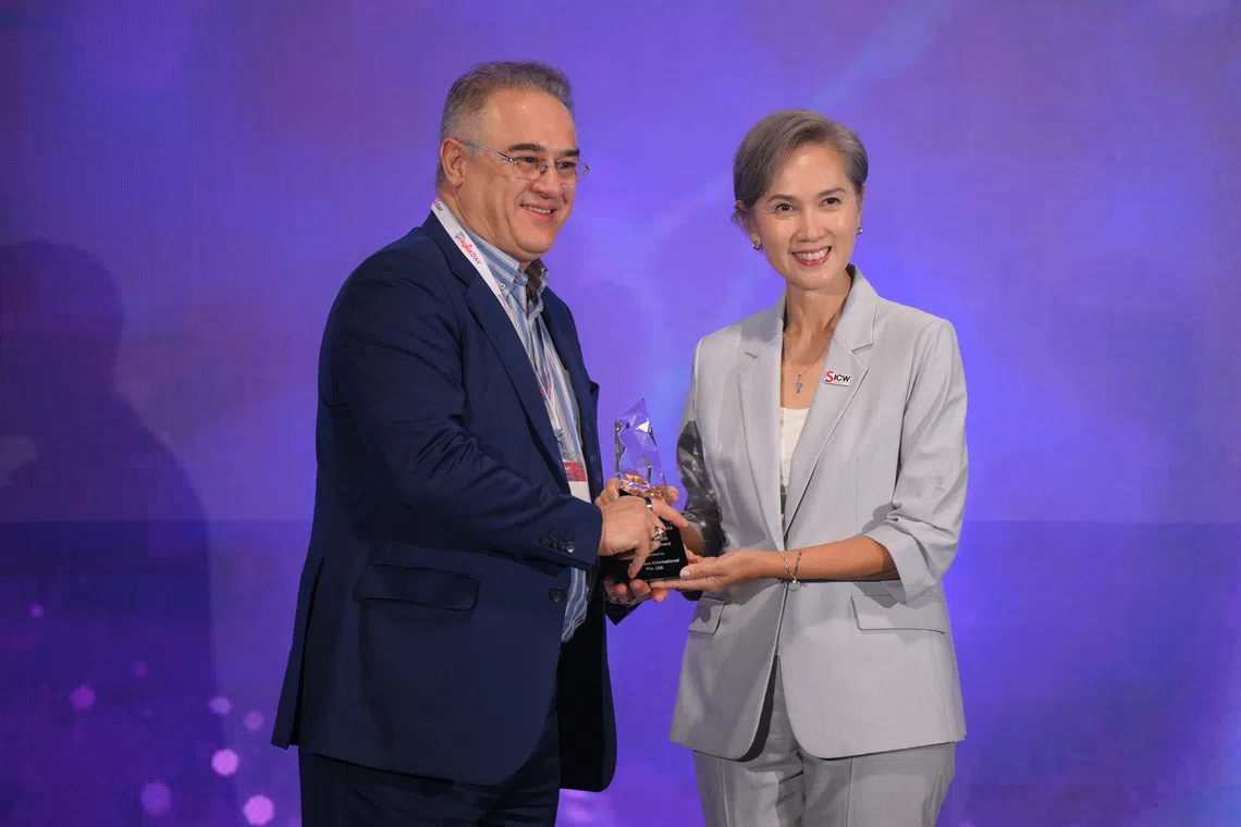 Blue Aqua International Group founder Dr. Farshad Shishehchian receives his award from Minister of Digital Development and Information Josephine Teo during the SME AI Impact Awards ceremony on Oct 13.