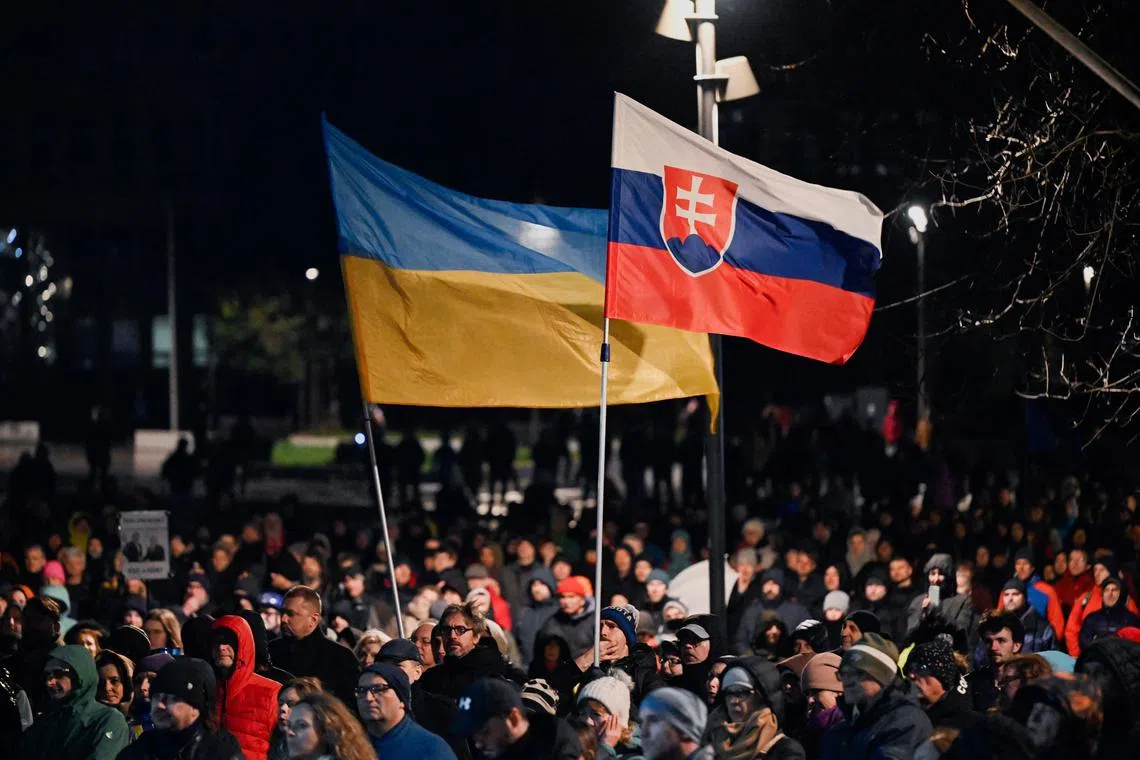 People hold Slovakian and Ukrainian flags, as demonstrators take part in a pro-Ukraine protest against the Slovak government's foreign policy, after Slovakia's Foreign Minister Juraj Blanar met with his Russian counterpart Sergei Lavrov, in Bratislava, Slovakia, March 12, 2024. REUTERS/Radovan Stoklasa