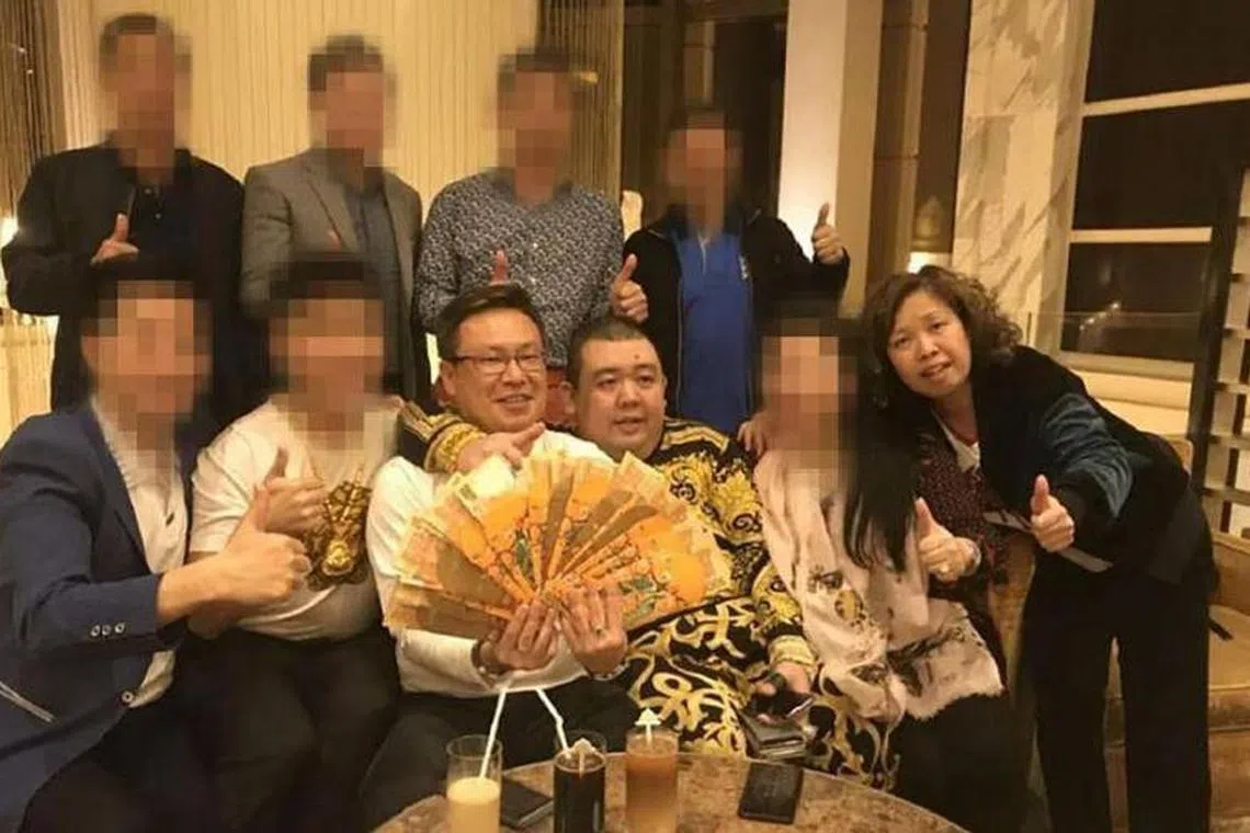 Mr Wan Hoe Keet (holding cash) and his wife Sally Ho, seen here with Mr Peter Ong, at a 2018 meeting in Macau.