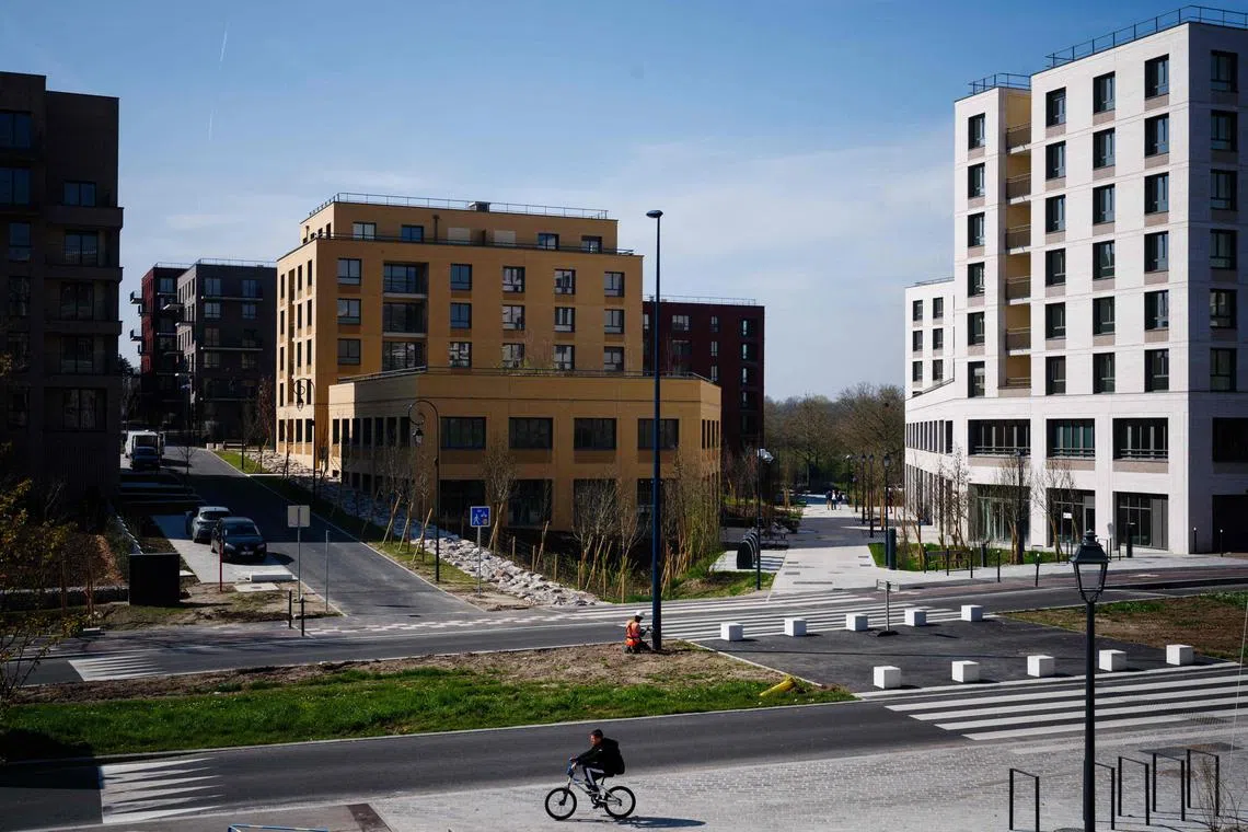 This photograph taken on March 22, 2024, shows a worker fixing a lighting pole at the Media Village that will host journalists from around the world during the Paris 2024 Olympics.
