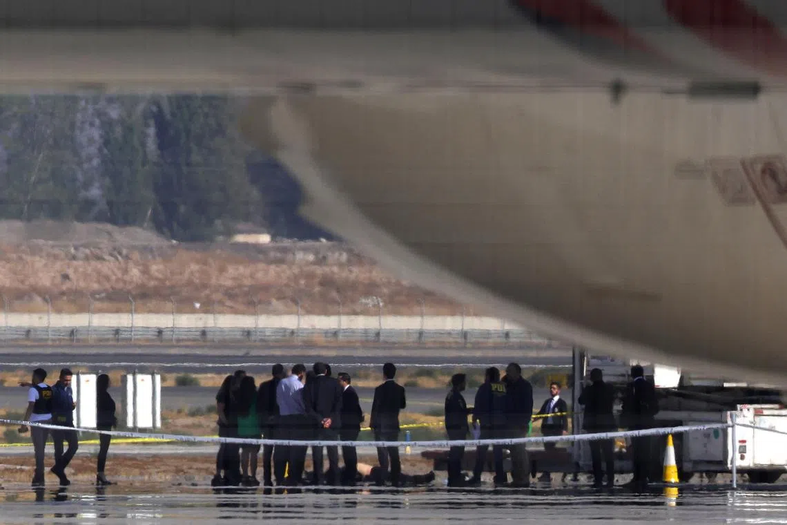 Investigation police officers inspect a body on Santiago de Chile Airport slab after a valuables truck attempted robbery left two people dead in the midst of an intense firefight, police and local media reported, in Santiago, Chile, March 8, 2023. REUTERS/Ivan Alvarado