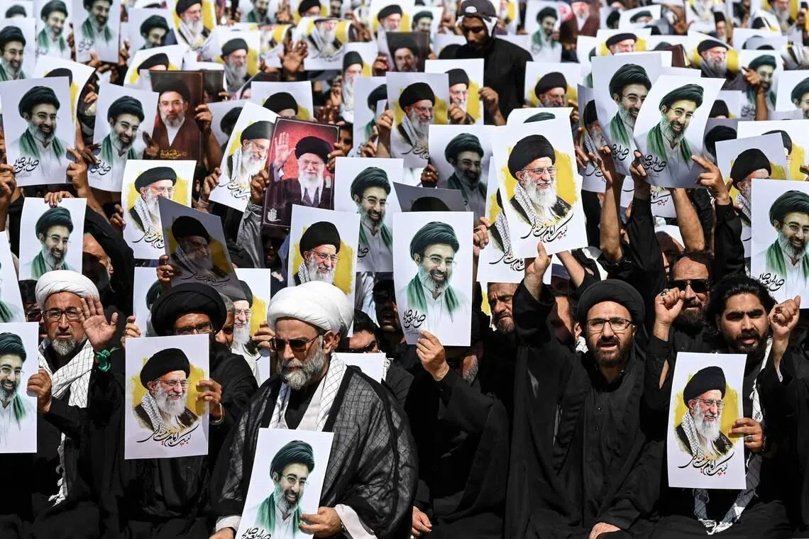 Shia Muslims holding portraits of Iran’s slain supreme leader Ali Khamenei and of his son, the country's new supreme leader Mojtaba Khamenei, shouting anti-US-Israel slogans during the Youm-e-Ali procession in Karachi on March 11 marking the death anniversary of Imam Ali, son-in-law of Prophet Muhammad. 