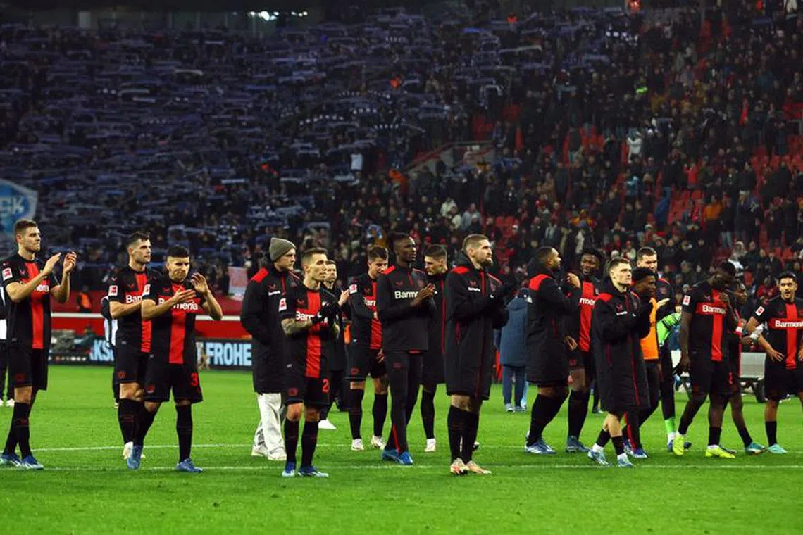 Soccer Football - Bundesliga - Bayer Leverkusen v VfL Bochum - BayArena, Leverkusen, Germany - December 20, 2023 Bayer Leverkusen players celebrate in front of fans after the match REUTERS/Thilo Schmuelgen