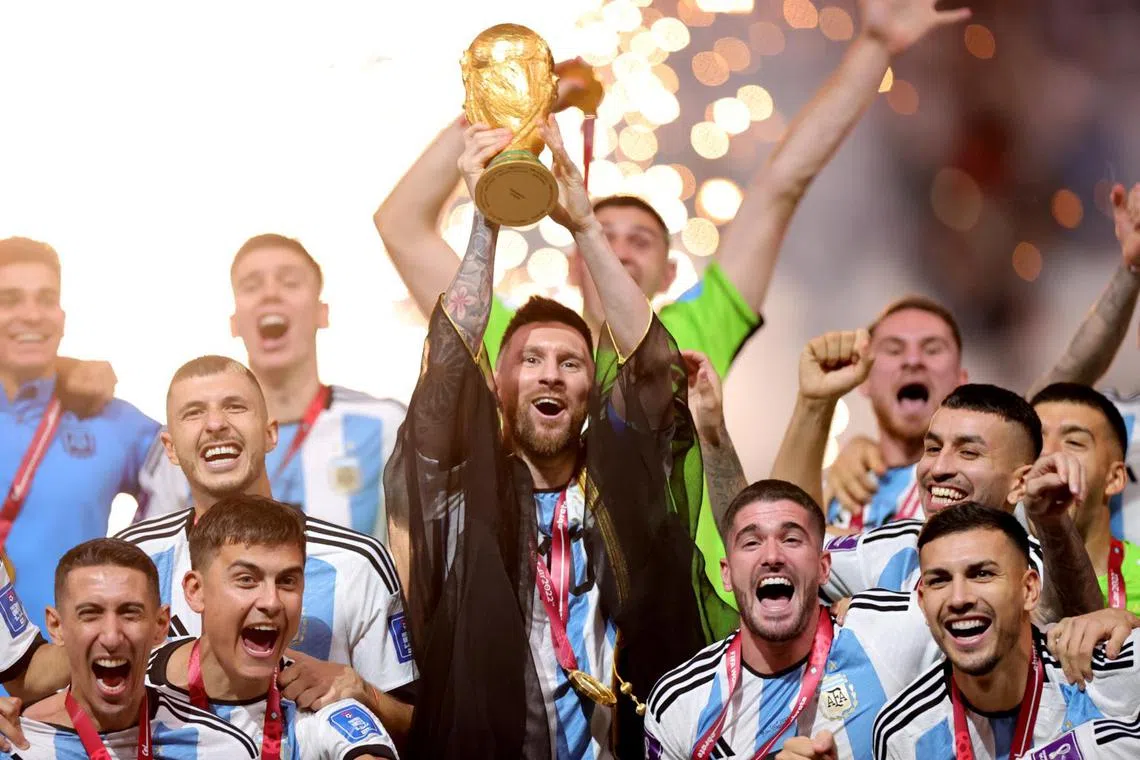 Lionel Messi (centre) of Argentina lifts the World Cup trophy after winning the FIFA World Cup 2022, at Lusail stadium, Lusail, Qatar, on Dec 18, 2022.