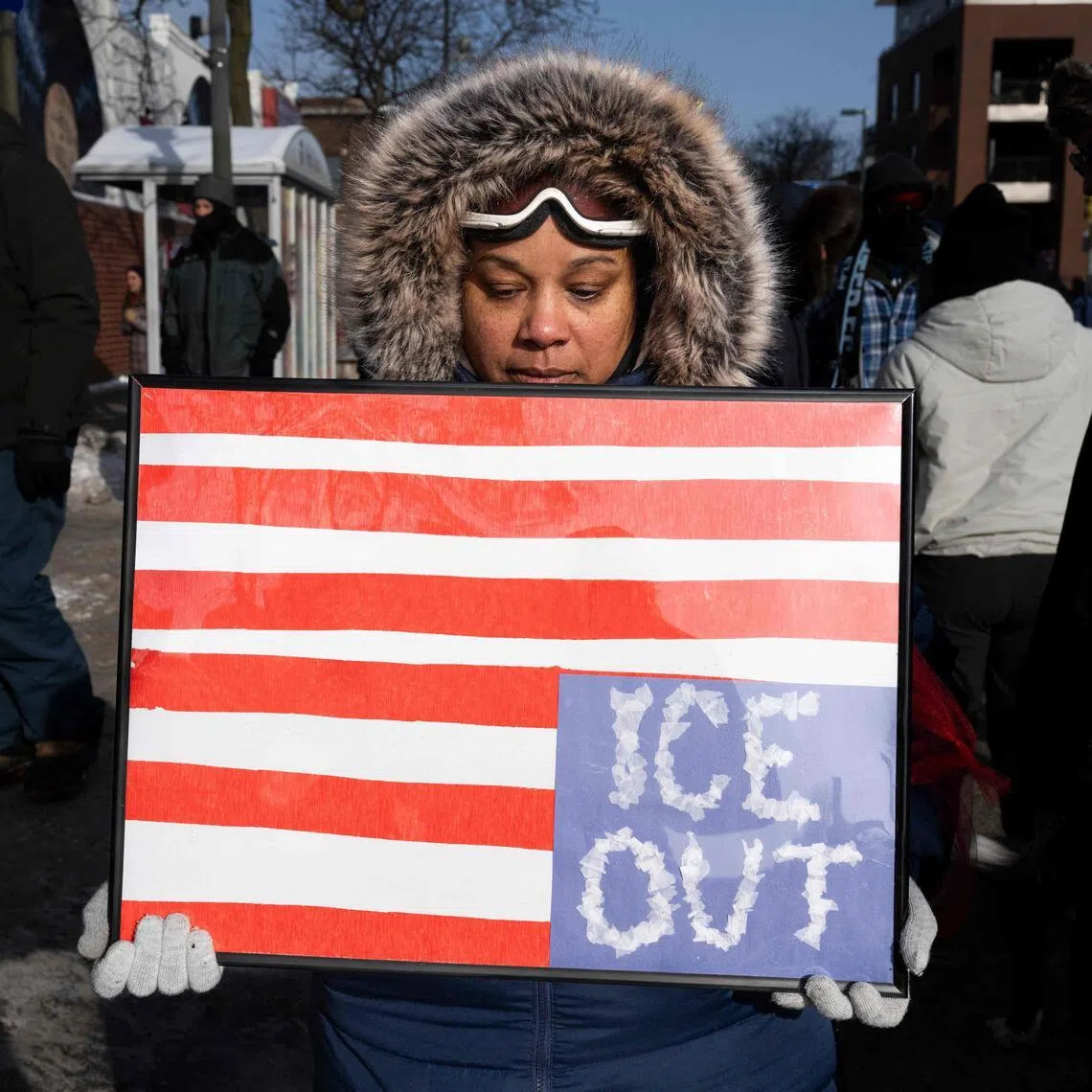 A woman holds a placard with an upside down American flag in Minneapolis, Minnesota, on Jan 25, 2026, as the backlash against an immigration crackdown grows across the country. PHOTO: AFP
