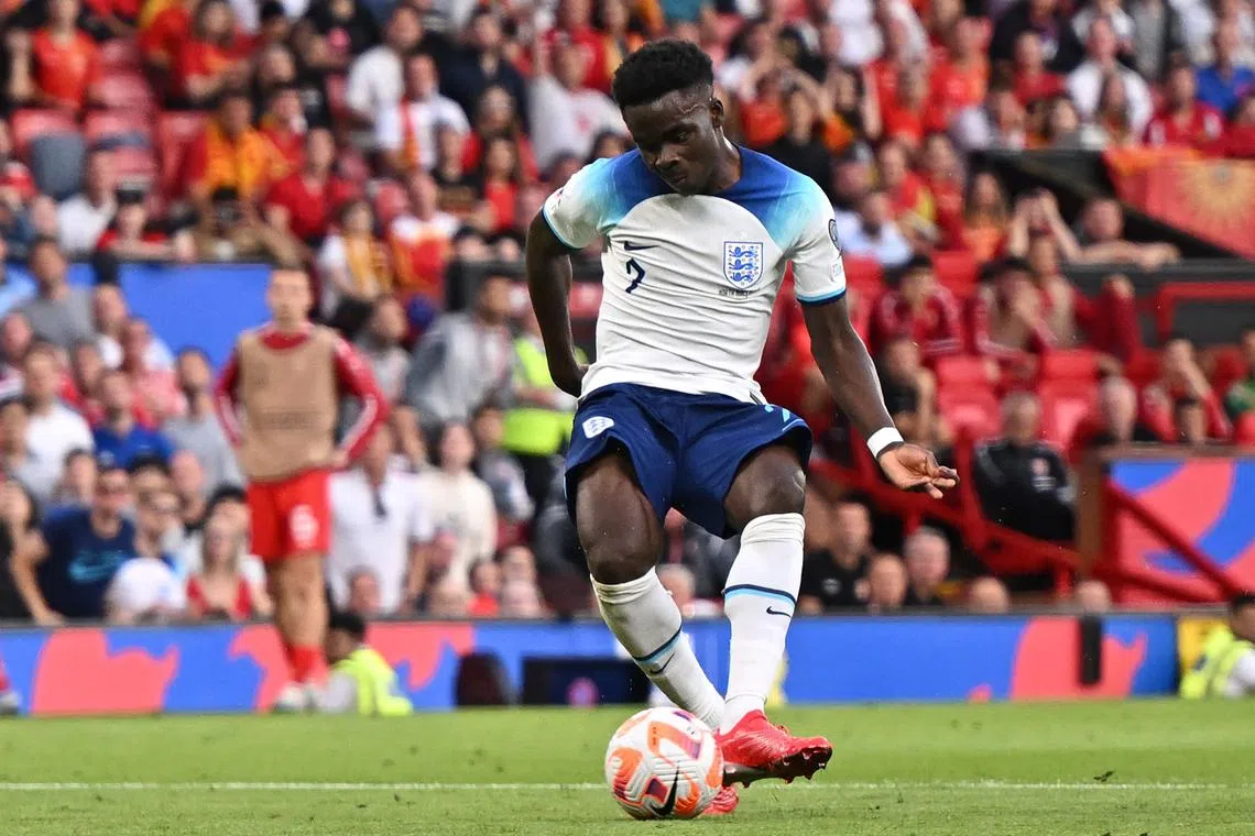 England's midfielder Bukayo Saka shoots to score his third goal.