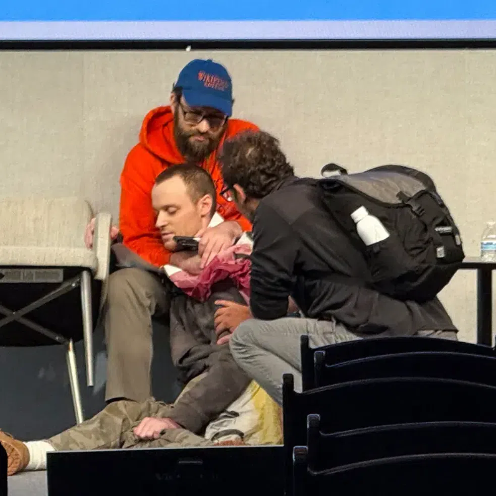 Mr Richard Knipel, rear, rushed to grab a man with a gun who threatened to kill himself at a Wikipedia conference.

