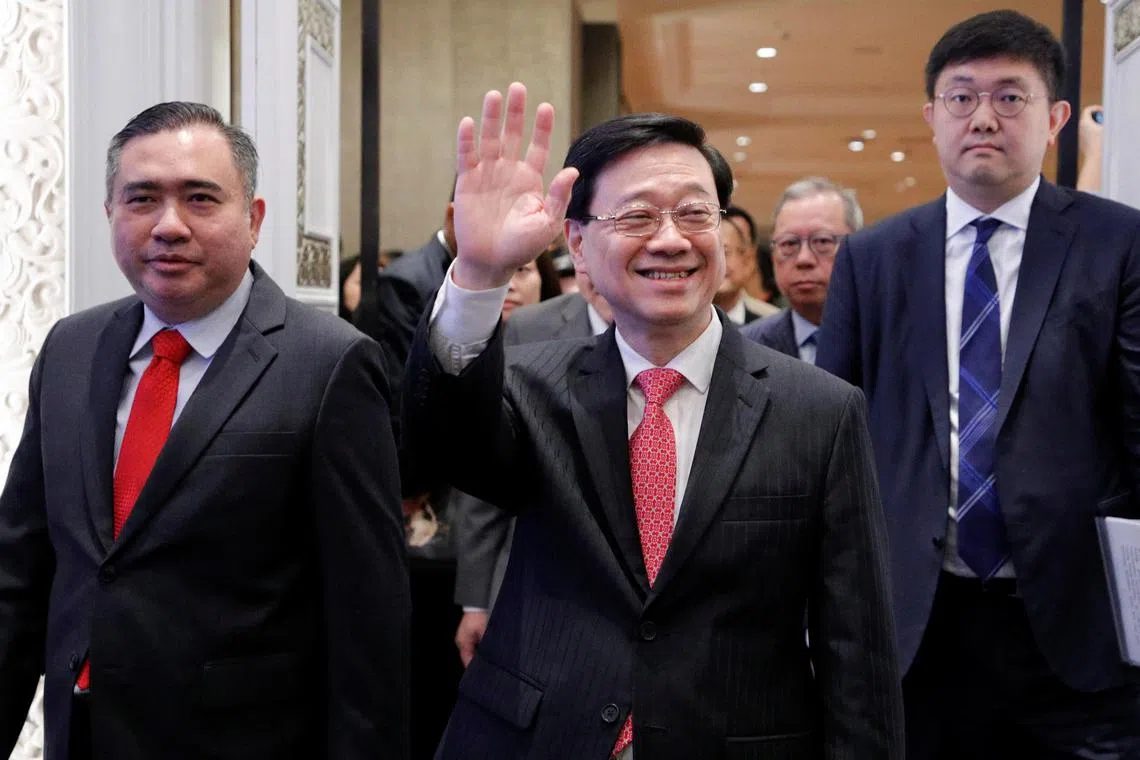Hong Kong Chief Executive John Lee (centre), accompanied by Malaysia Transport Minister Anthony Loke (left), waves to the attendees of Malaysia-Hong Kong business luncheon during his visit to Kuala Lumpur, Malaysia on July 28, 2023. 