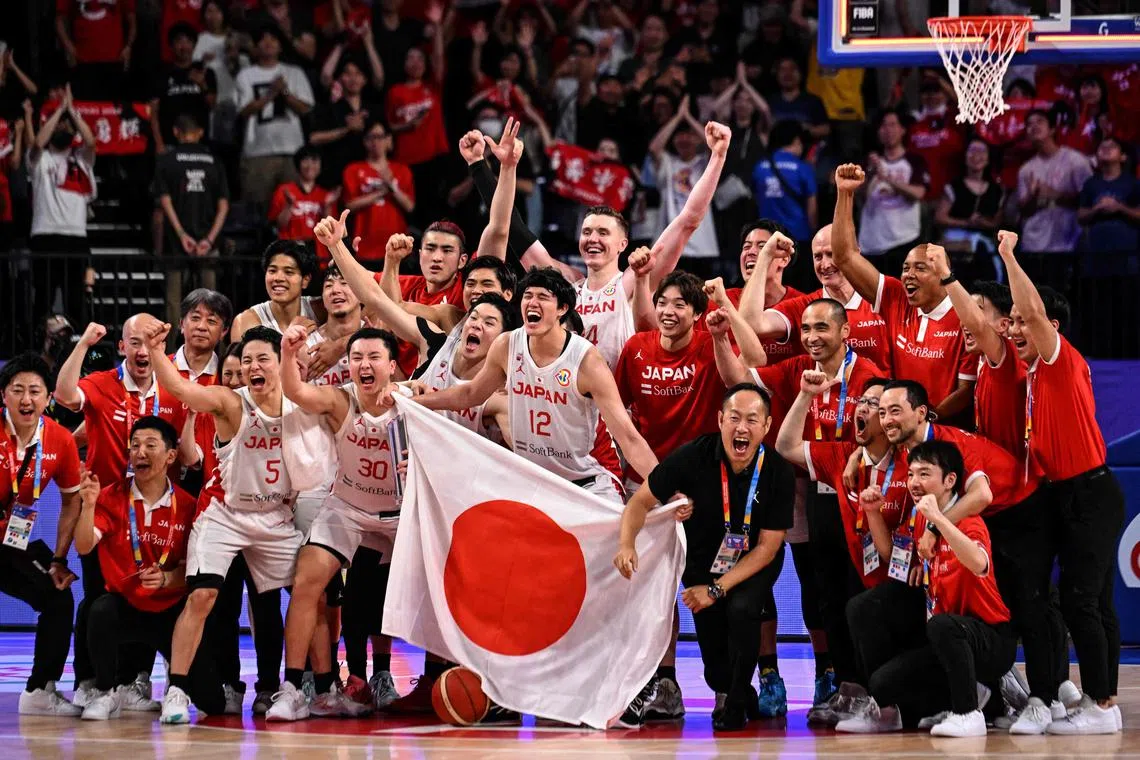 Members of Team Japan celebrating the 80-71 Basketball World Cup victory over Cape Verde at Okinawa Arena on Saturday, which sealed their qualification for the Paris Olympics in 2024.
