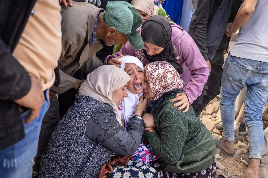 Women reacting as volunteers recover the body of a familly member from the rubble of collapsed houses in the village of Imi N'Tala near Amizmiz, in central Morocco, after the deadly 6.8-magnitude earthquake, on Sept 10, 2023. 