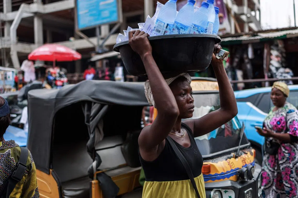 A lady sells water at the Lagos island market in Lagos on March 8, 2024, ahead of the holy fasting month of Ramadan. (Photo by Benson Ibeabuchi / AFP)