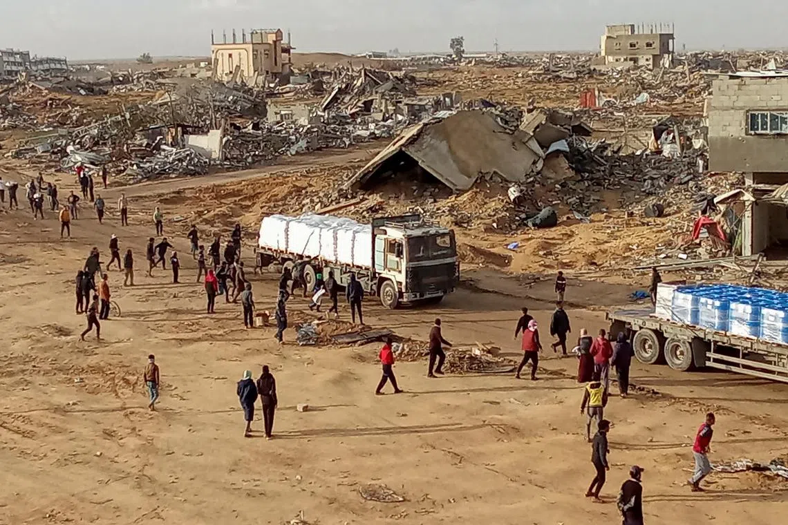 FILE PHOTO: Palestinians attempt to grab aid from a truck in Rafah in the southern Gaza Strip, January 23, 2025. REUTERS/Hussam Al-Masri/File Photo