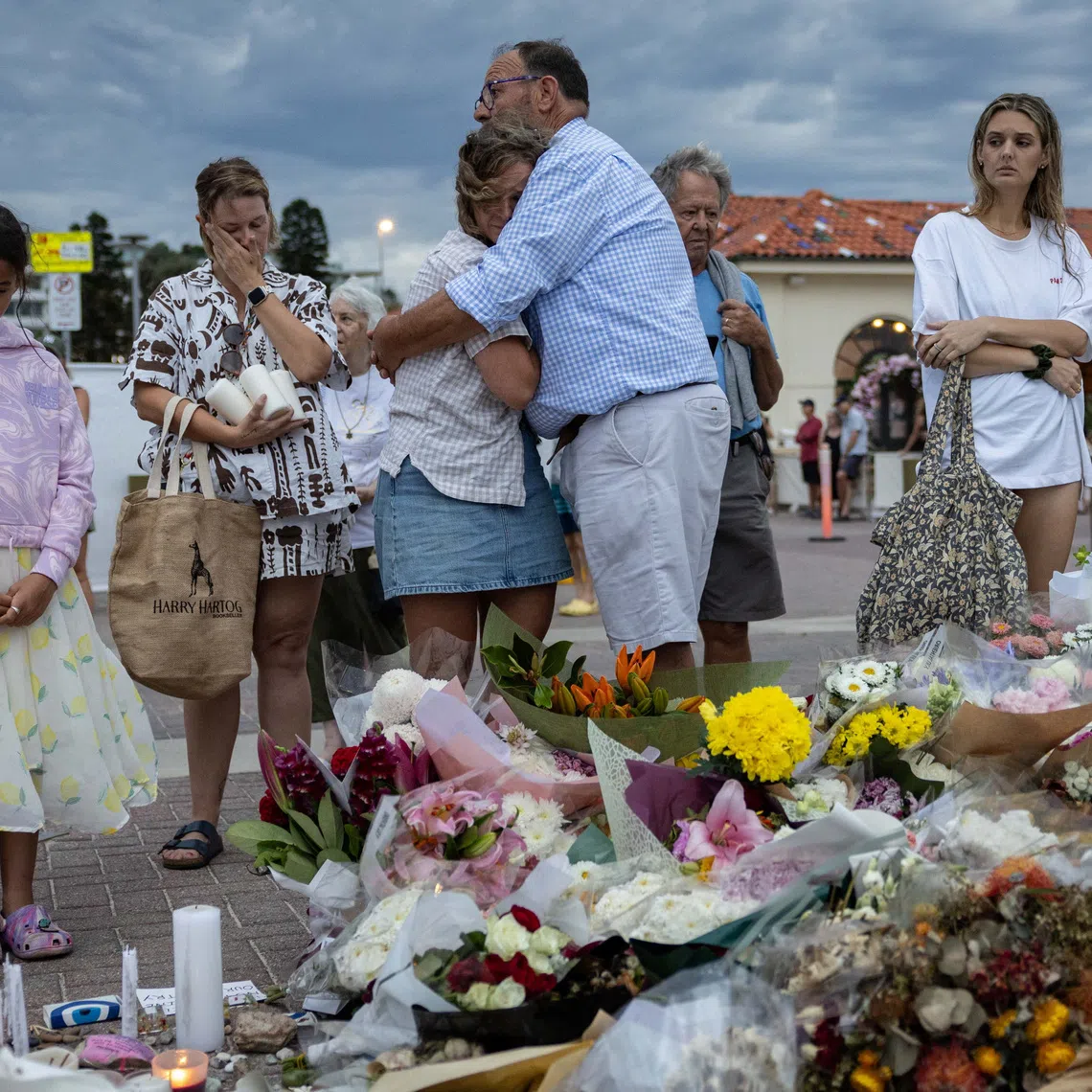 People mourn near floral tributes placed for victims and survivors of the Dec 14 mass shooting at Bondi Beach on Dec 21.