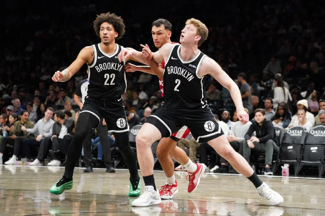 Danny Wolf and Jalen Wilson of the Brooklyn Nets fight for position with Nimrod Levi of Hapoel Jerusalem B.C. during a pre-season game. 