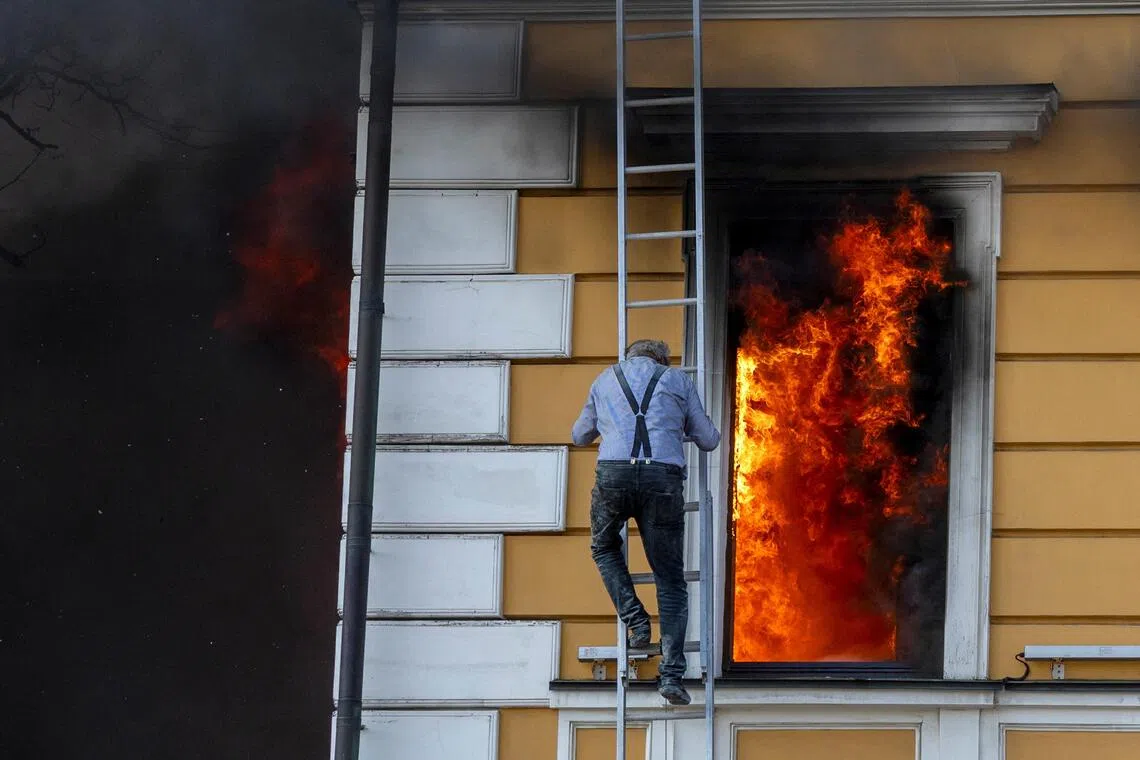 A man escaping from the National Academy of Sciences in Kyiv, Ukraine, after it was hit by a Russian jet-powered drone on Sept 28.