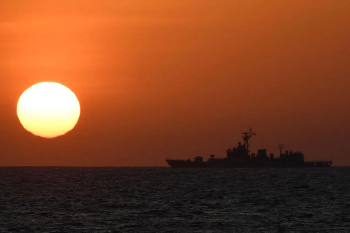 (FILES) This photo taken on February 15, 2024 shows a Chinese navy ship sailing during the sunrise near the China-controlled Scarborough Shoal, in the disputed waters of the South China Sea. China warned the Philippines on August 10 to stop "infringement" around a disputed reef in the South China Sea, after the Philippines said one of its planes was harassed by the Chinese air force. (Photo by Ted ALJIBE / AFP)