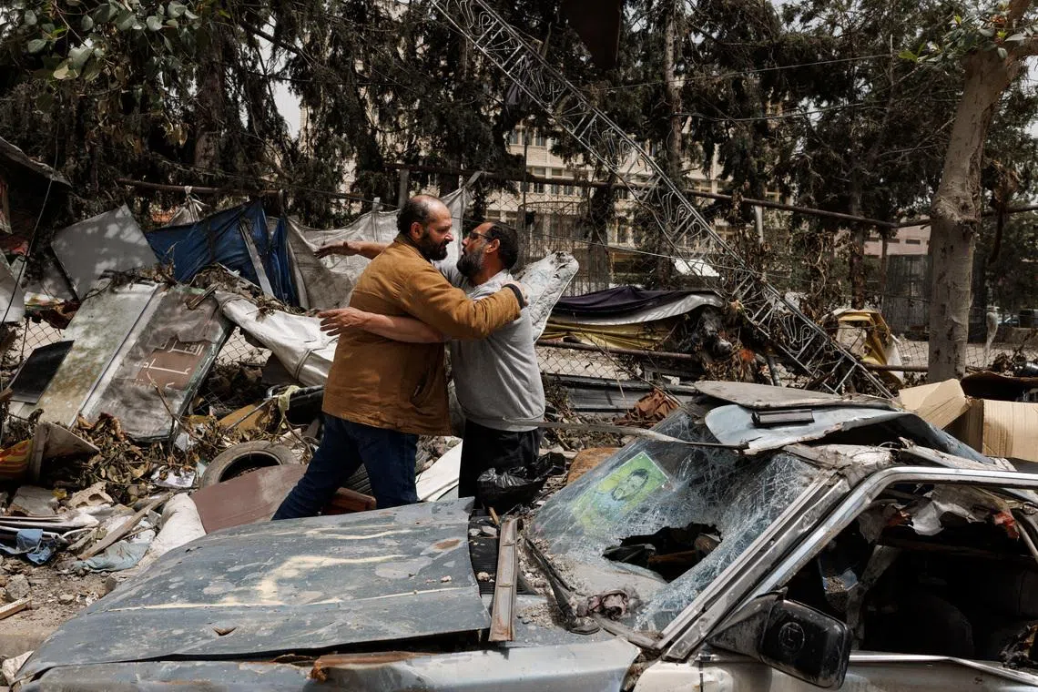 Hussein Kouhail, a displaced resident, hugging a friend beside his car, which was damaged by an Israeli strike on March 28 that forced him to flee to Sidon, upon returning home after a 10-day ceasefire between Lebanon and Israel went into effect, in Nabatieh, Lebanon, April 18.