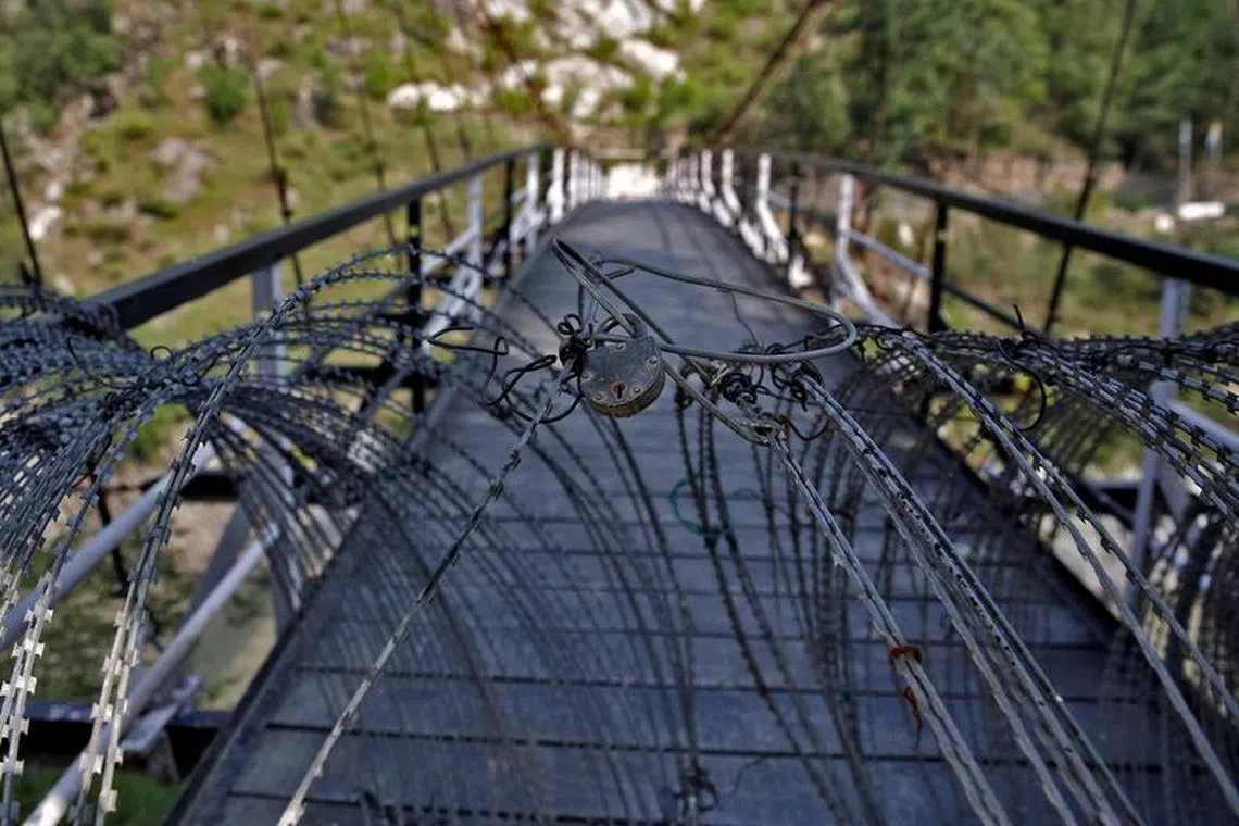 FILE PHOTO: A view shows a padlock on concertina wires on a footbridge connecting Indian administered Kashmir and Pakistan administered Kashmir in Teetwal in north Kashmir's Kupwara district August 9, 2022. REUTERS/Danish Ismail/File Photo