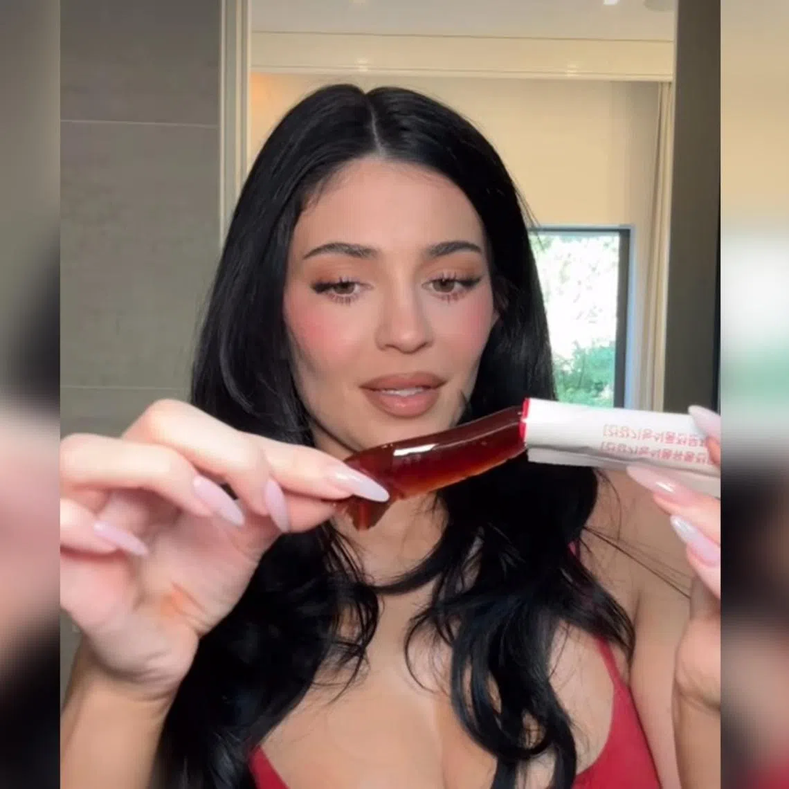 Kylie Jenner filming herself with the Foodology Coleology Cutting Jelly, a stick-type jelly supplement.