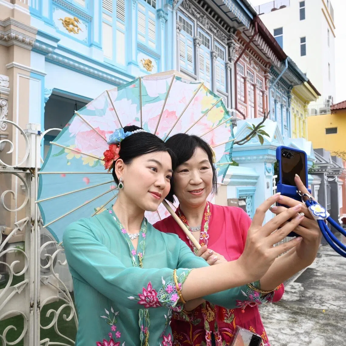 Tourists from China – Ms Cynthia Si, 30, and her mother, Ms Mia Cheng, 52 –  taking photos against the backdrop of colourful Peranakan houses in Koon Seng Road in Joo Chiat on Feb 20.