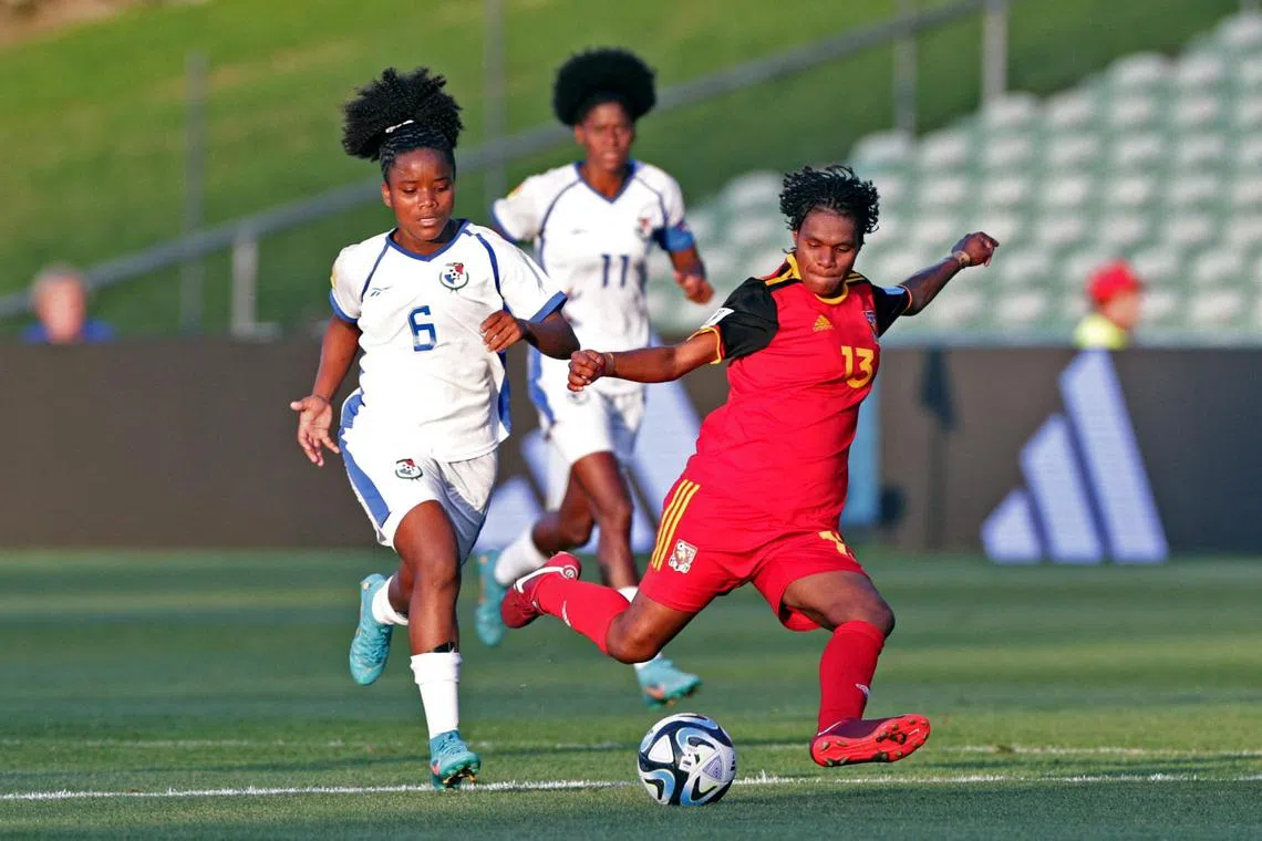 Papua New Guinea's Ramona Padio (in red) attempting a shot as Panama's Deysire Salazar and Natalia Mills looks on.