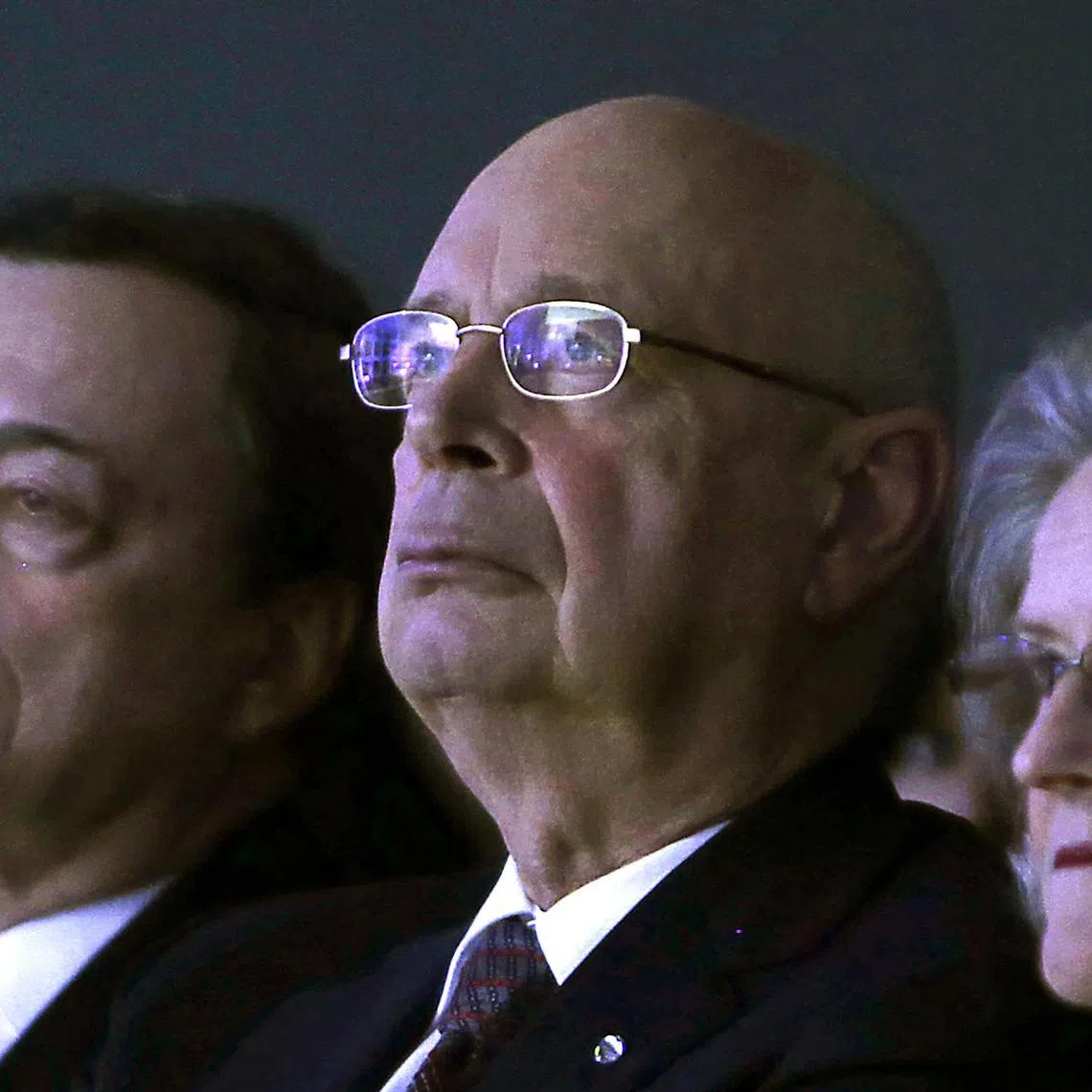 (FILES) World Economic Forum founder Klaus Schwab (C) and his wife Hilde (R) listen to a speech by the US secretary of state at the World Economic Forum in Davos on January 24, 2014. An investigation conducted by the World Economic Forum's board has cleared the body's founder Klaus Schwab and his wife of wrongdoing, after whistleblower complaints, it said on August 15, 2025. (Photo by GARY CAMERON / POOL / AFP)