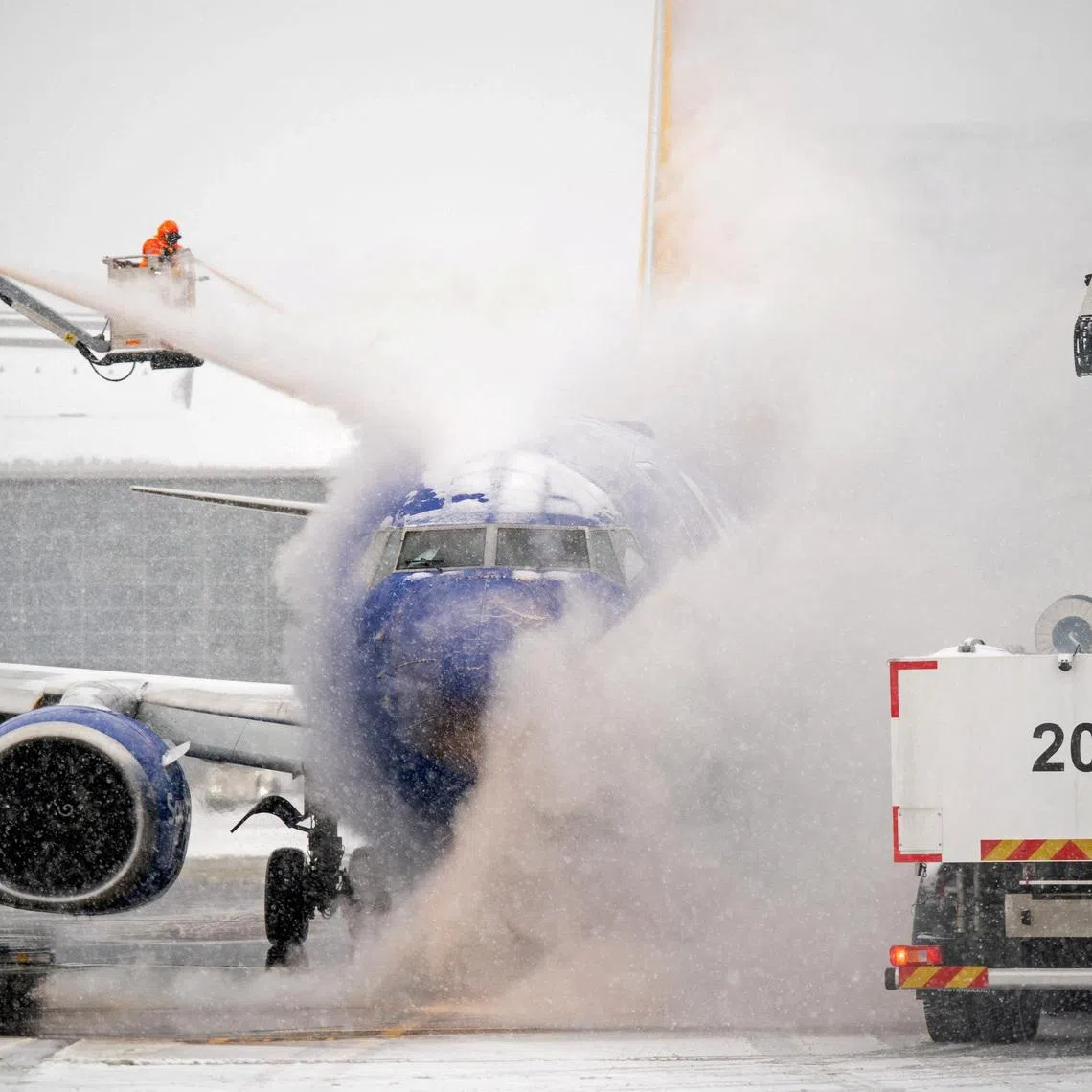 A de-icing crew works during winter storm Fern on a Southwest Airlines flight at Nashville International Airport in Nashville, Tennessee, U.S. on Jan 24, 2026.  Andrew Nelles/USA Today Network via REUTERS    NO 
