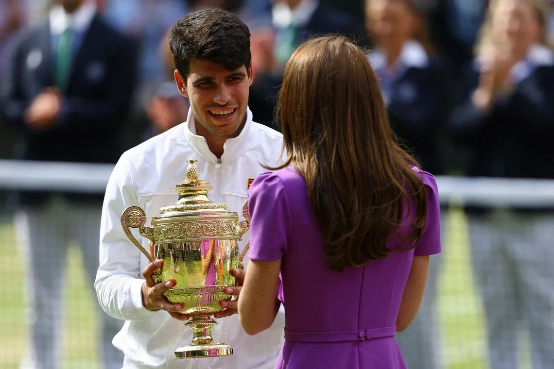 Tennis - Wimbledon - All England Lawn Tennis and Croquet Club, London, Britain - July 14, 2024 Spain's Carlos Alcaraz is awarded with the trophy by Britain's Catherine, Princess of Wales after winning his men's singles final against Serbia's Novak Djokovic REUTERS/Hannah Mckay