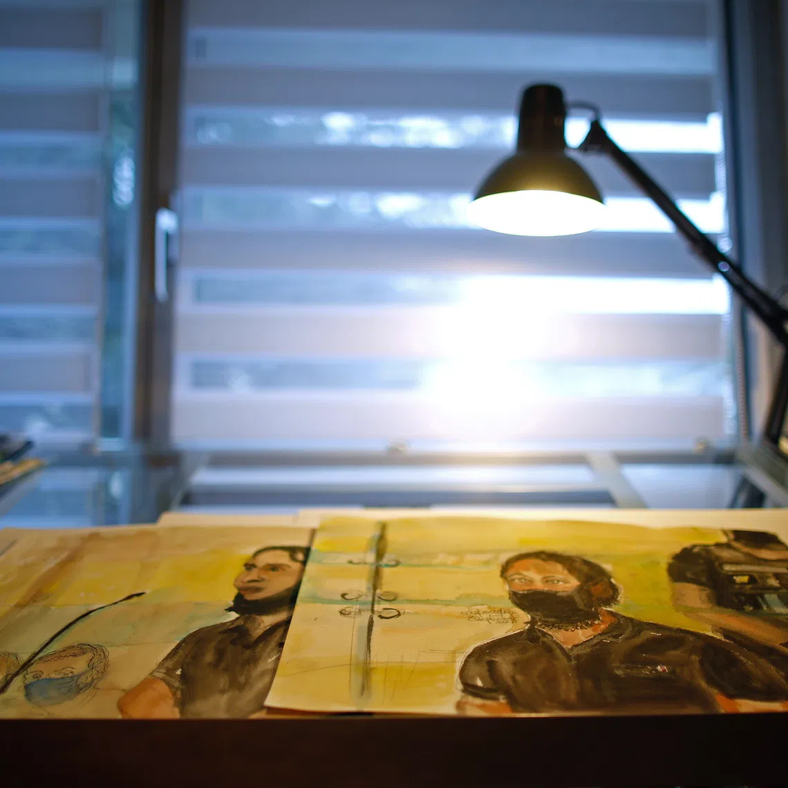 French court artist Elisabeth de Pourquery's sketches showing Salah Abdeslam, one of the accused, who is widely-believed to be the only surviving member of the group suspected of carrying out the Paris' November 2015 attacks, are displayed on a desk during an interview with Reuters at her home near Paris, France, September 27, 2021. Picture taken September 27, 2021. REUTERS/Gonzalo Fuentes