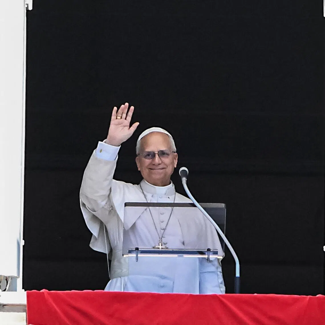 Pope Leo XIV waves from the window of the apostolic palace overlooking St Peter's square during the Regina Coeli prayer in The Vatican on April 26, 2025.