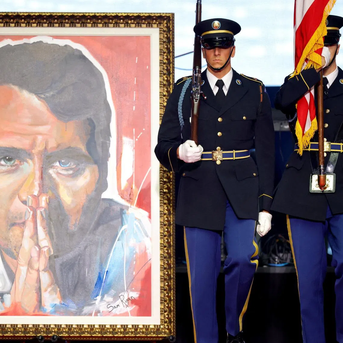 U.S. soldiers stand next to the portrait of slain conservative commentator Charlie Kirk during his memorial service at State Farm Stadium, Arizona, U.S., September 21, 2025.  REUTERS/Carlos Barria