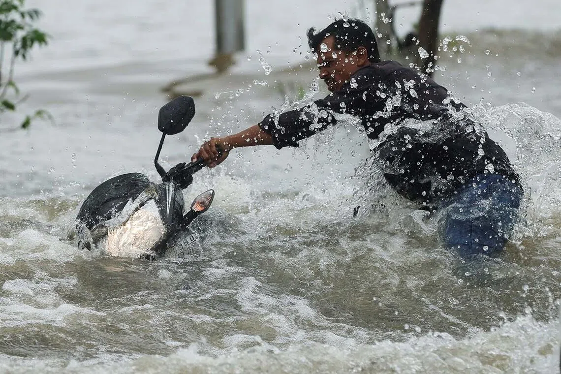 A man holds on to his motorbike after he was splashed by a car on a waterlogged road after heavy rainfall in Vasai, India, July 8, 2026. REUTERS/Francis Mascarenhas TPX IMAGES OF THE DAY