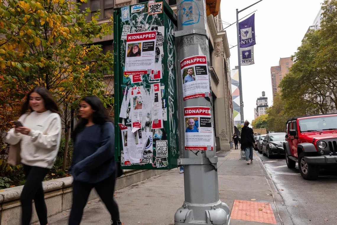Posters of some of those kidnapped by Hamas in Israeli are displayed on a pole outside of New York University.