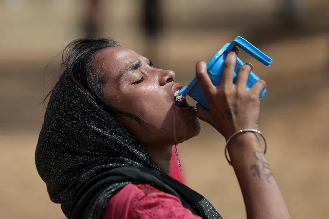 A woman drinks water from a mug on a hot summer day in New Delhi, India June 9, 2023. REUTERS/Anushree Fadnavis/ File photo