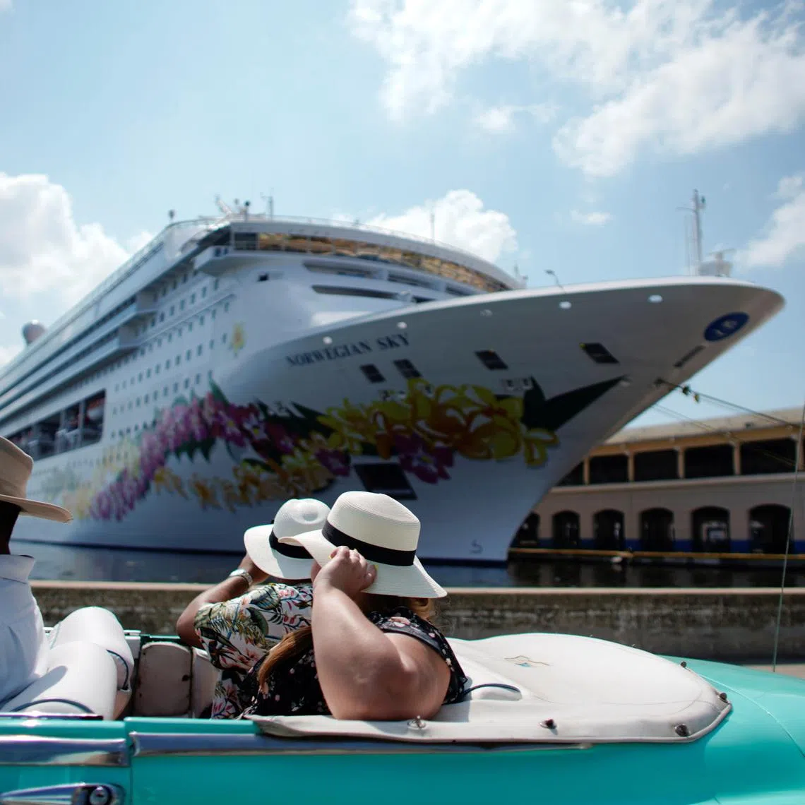 Tourists ride inside a vintage car as they pass by the Norwegian Sky cruise ship, operated by Norwegian Cruise Lines in Havana, Cuba, May 7, 2019. REUTERS/Alexandre Meneghini/File Photo