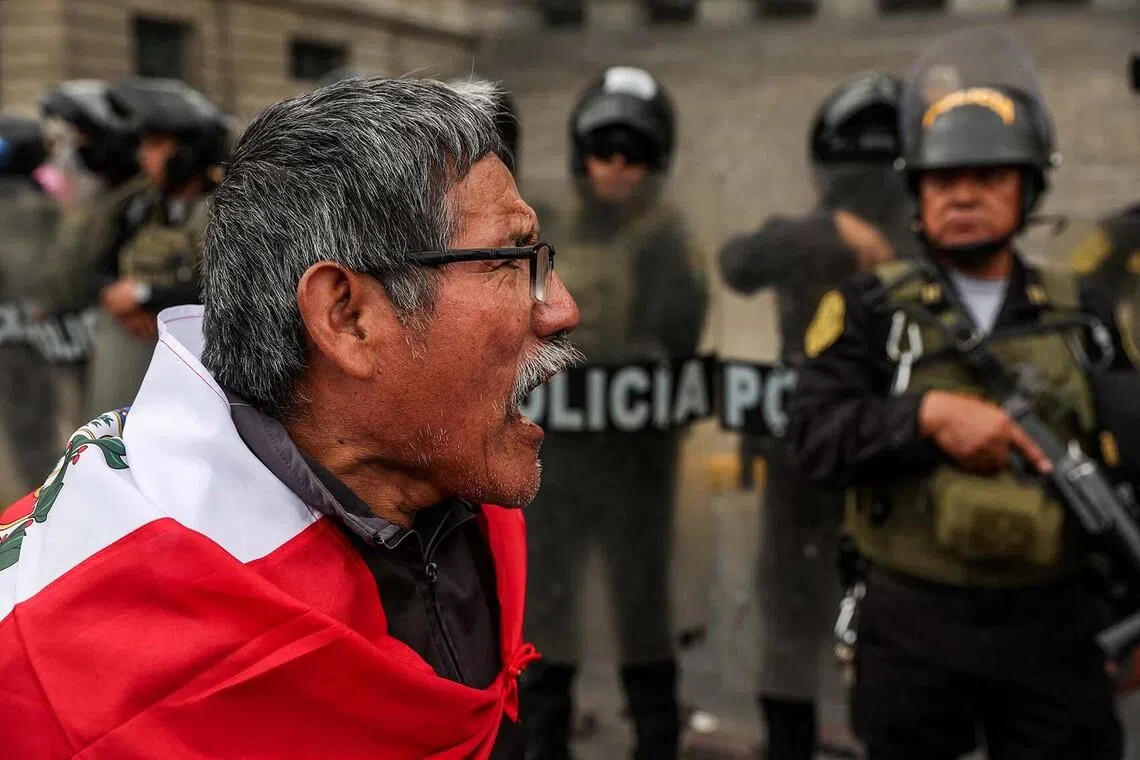 A man wrapped in a Peruvian flag shouts next to police officers in riot gear outside the Palace of Justice during a protest against the election results, on the day of President-elect Keiko Fujimori's swearing-in ceremony in Lima, Peru, July 28, 2026. REUTERS/Alessandro Cinque TPX IMAGES OF THE DAY