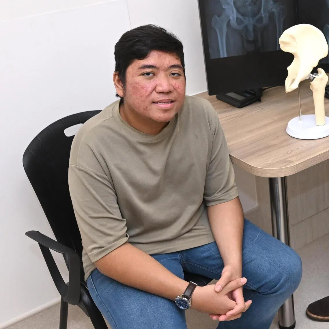 Lutfhil Hadi Azman - a slipped capital femoral epiphysis patient, who received a hip replacement at 18 - together with the doctors who performed surgery, Adjunct Associate Professor Andrew Lim and Adjunct Assistant Professor Barry Tan from the NUH Department of Orthopaedic Surgery. 