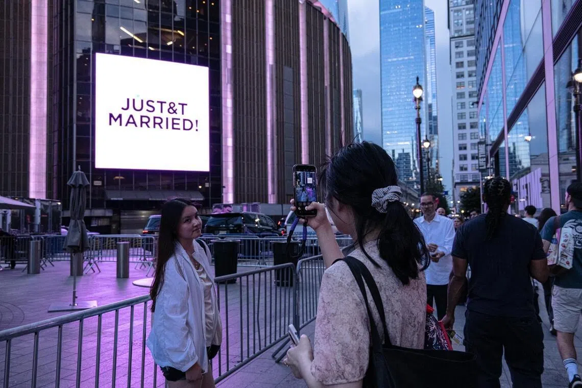 Swifties take photos outside Madison Square Garden during Taylor Swift and Travis Kelce’s wedding celebration in New York, on July 3.
