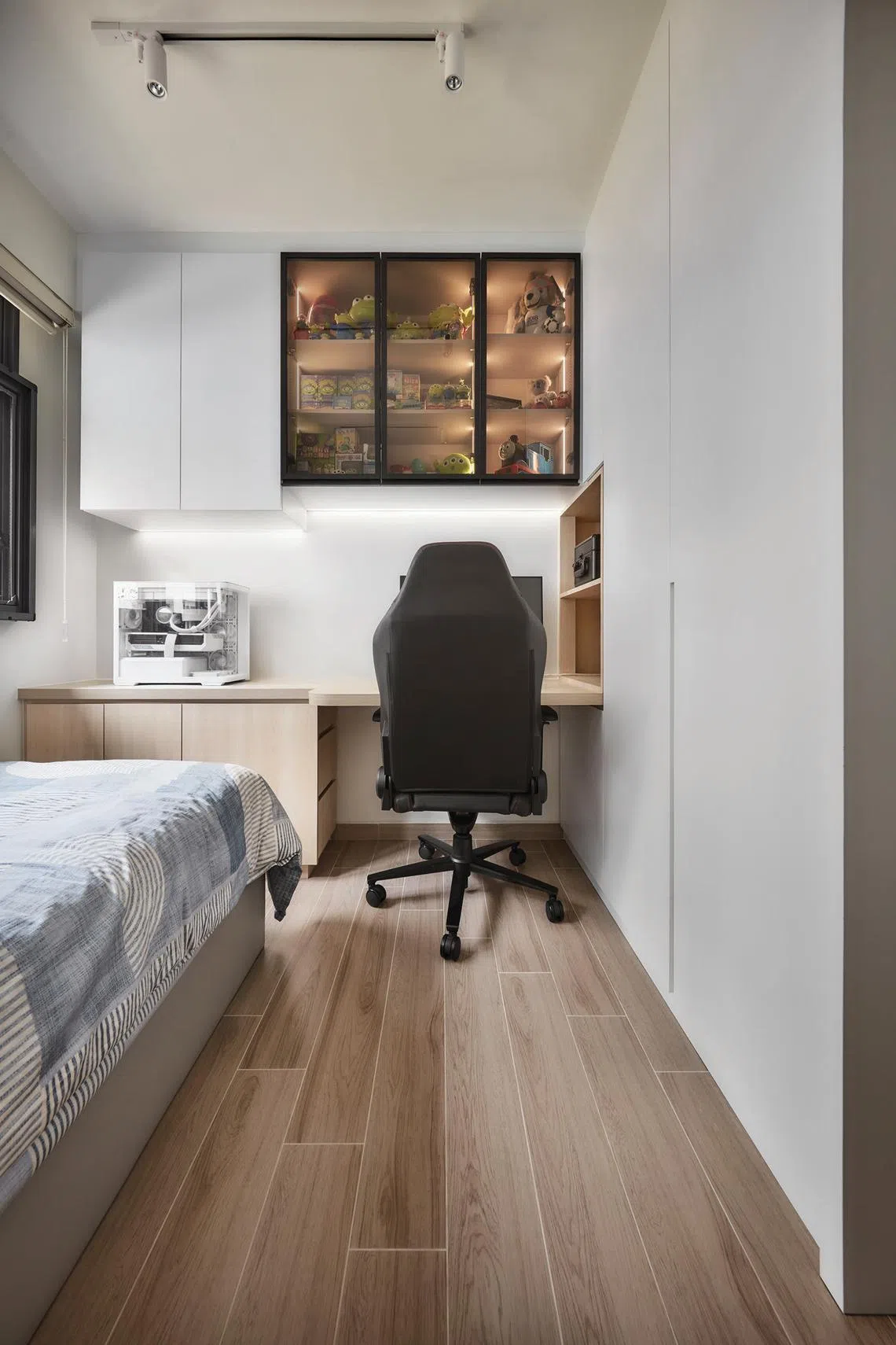 A glass-fronted display cabinet in the son’s bedroom showcases his keepsakes.