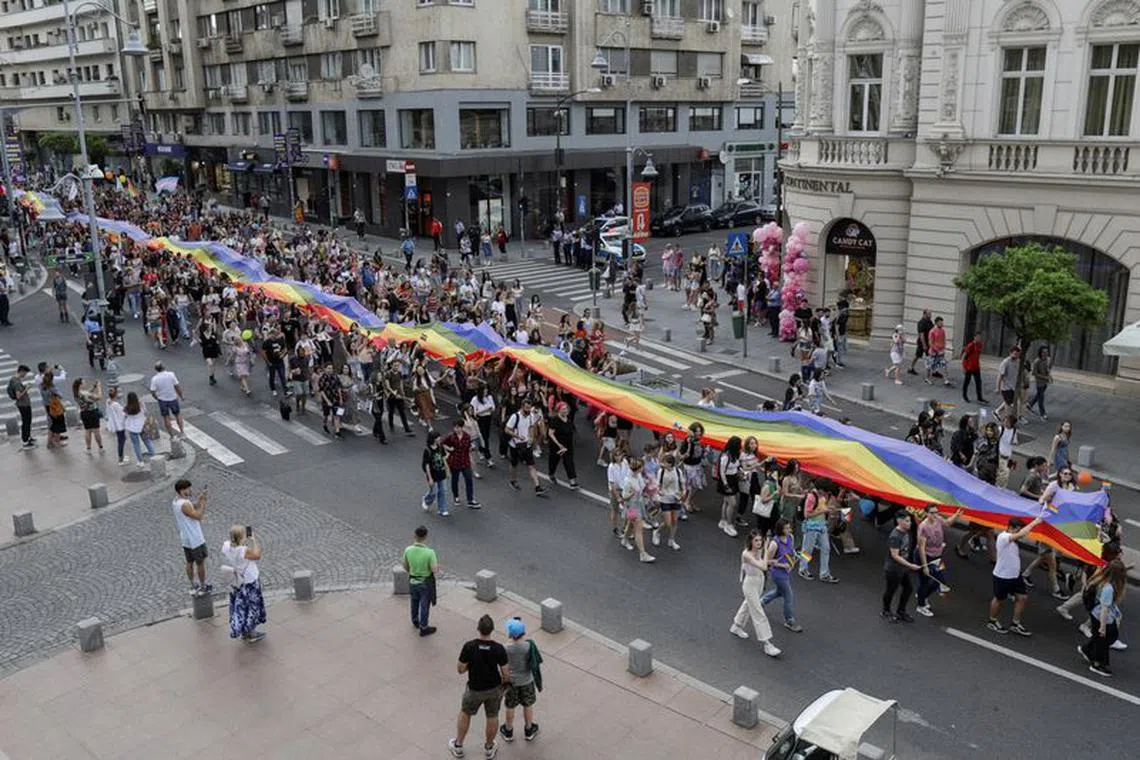 People taking part in the Bucharest Pride Parade carry a flag, in Bucharest, Romania, July 9, 2022. Inquam Photos/Octav Ganea via REUTERS/File Photo