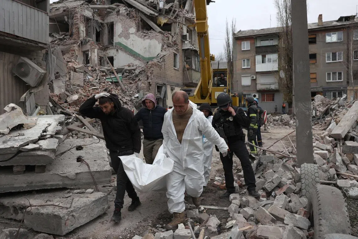 Rescue workers remove the remains of a person killed in Selydove, in Ukraine's Donetsk region, amid a Russian strike on a residential building.