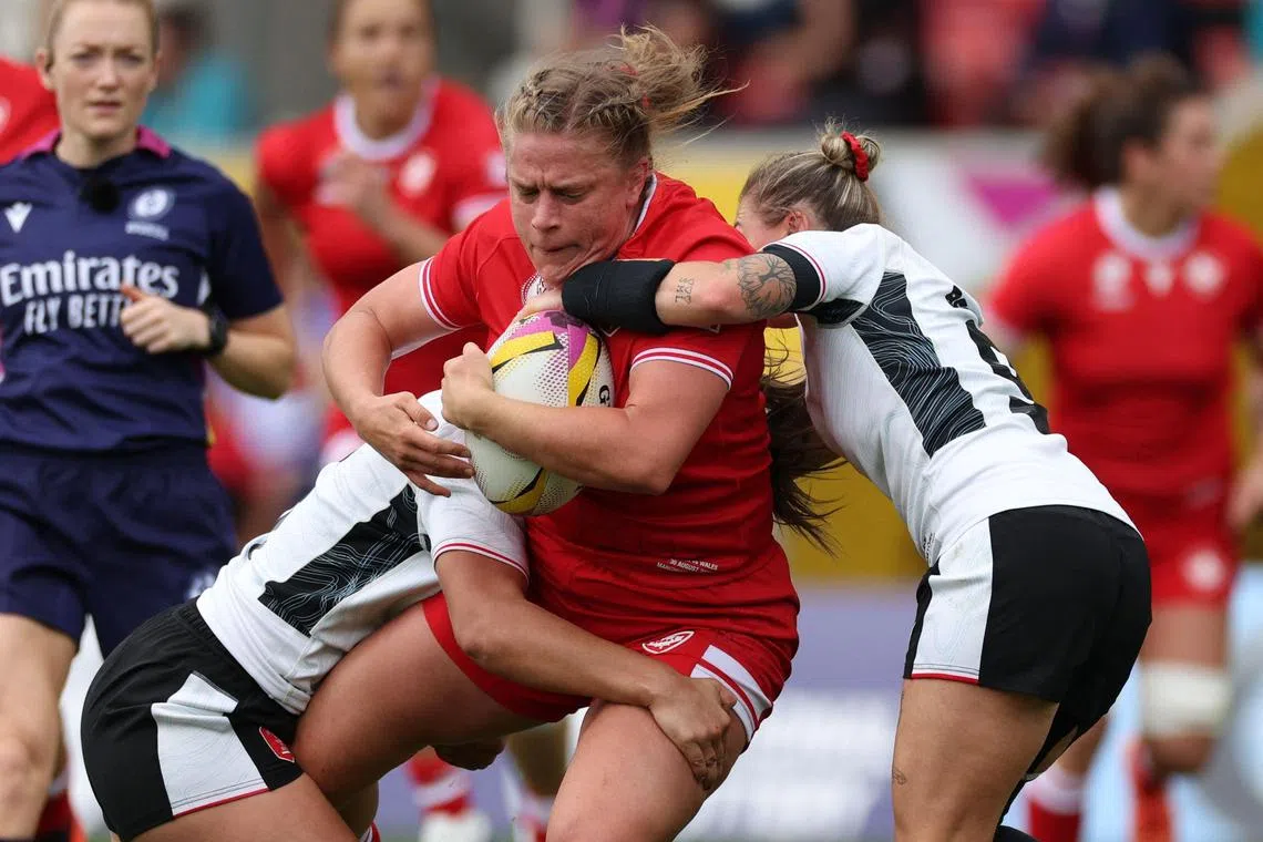Canada's hooker Emily Tuttosi is tackled in the Women’s Rugby World Cup pool B match against Wales at Salford Community Stadium in Manchester on Aug 30, 2025.