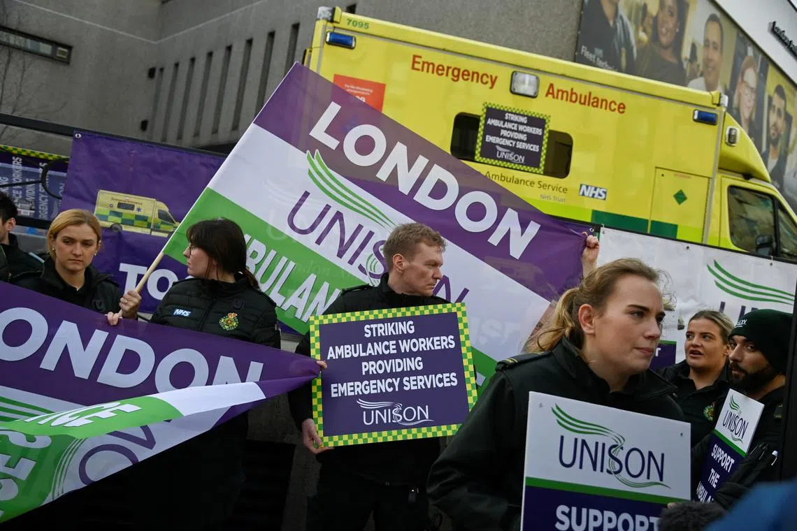 Ambulance workers strike outside Waterloo station in London on Jan 11, 2023.